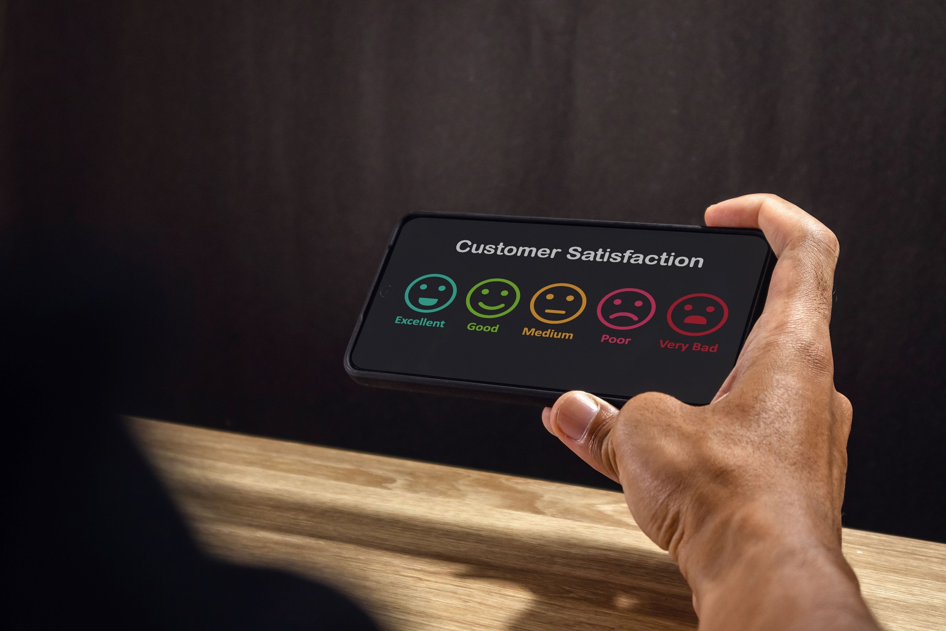 Man holding a smartphone to give rating to service experience. Customer review satisfaction feedback concept.